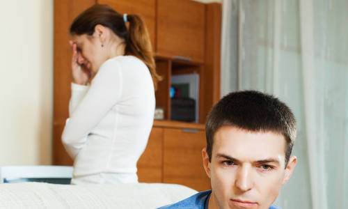 Family conflict. Young couple after quarrel in living room at home